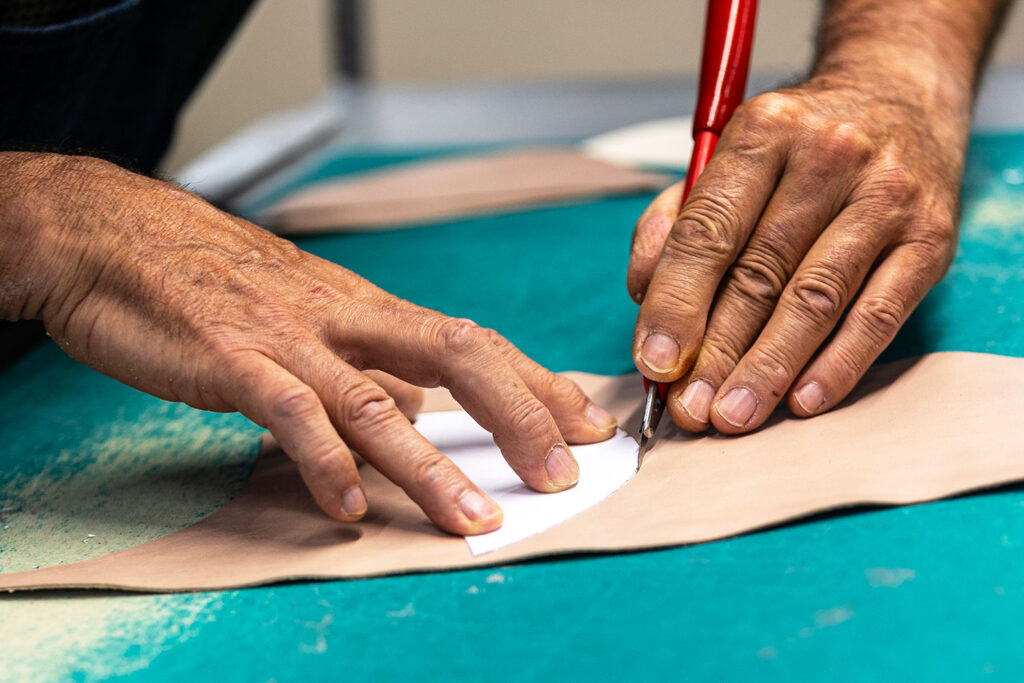 Maestro artigiano Cavallini mentre ritaglia una tomaia in pelle nel laboratorio di Santa Maria a Monte