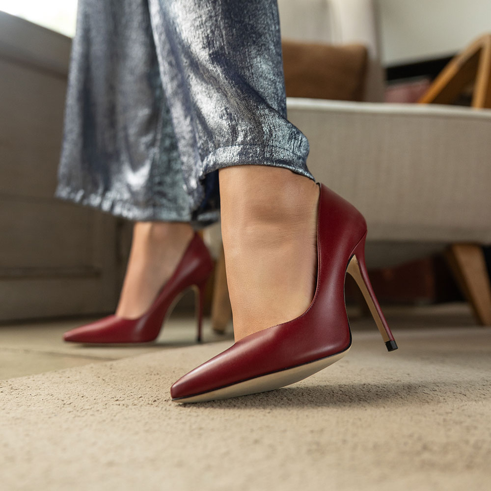 cavallini_ambientata_Gitana_malaga Scarpa decollete donna in pelle rossa con tacco 10 cm, indossata su pavimento beige in ambiente domestico - Cavallini
